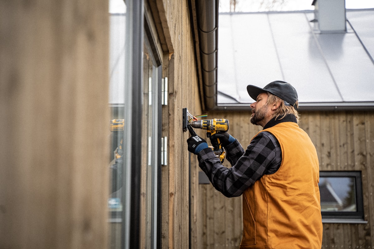 Albrecht Electric technician installing an exterior electrical fixture